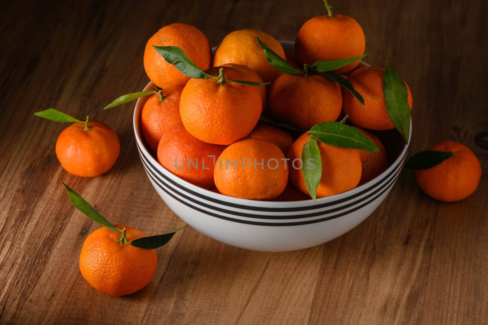 fresh juicy tangerines in a white bowl on a wooden table 2