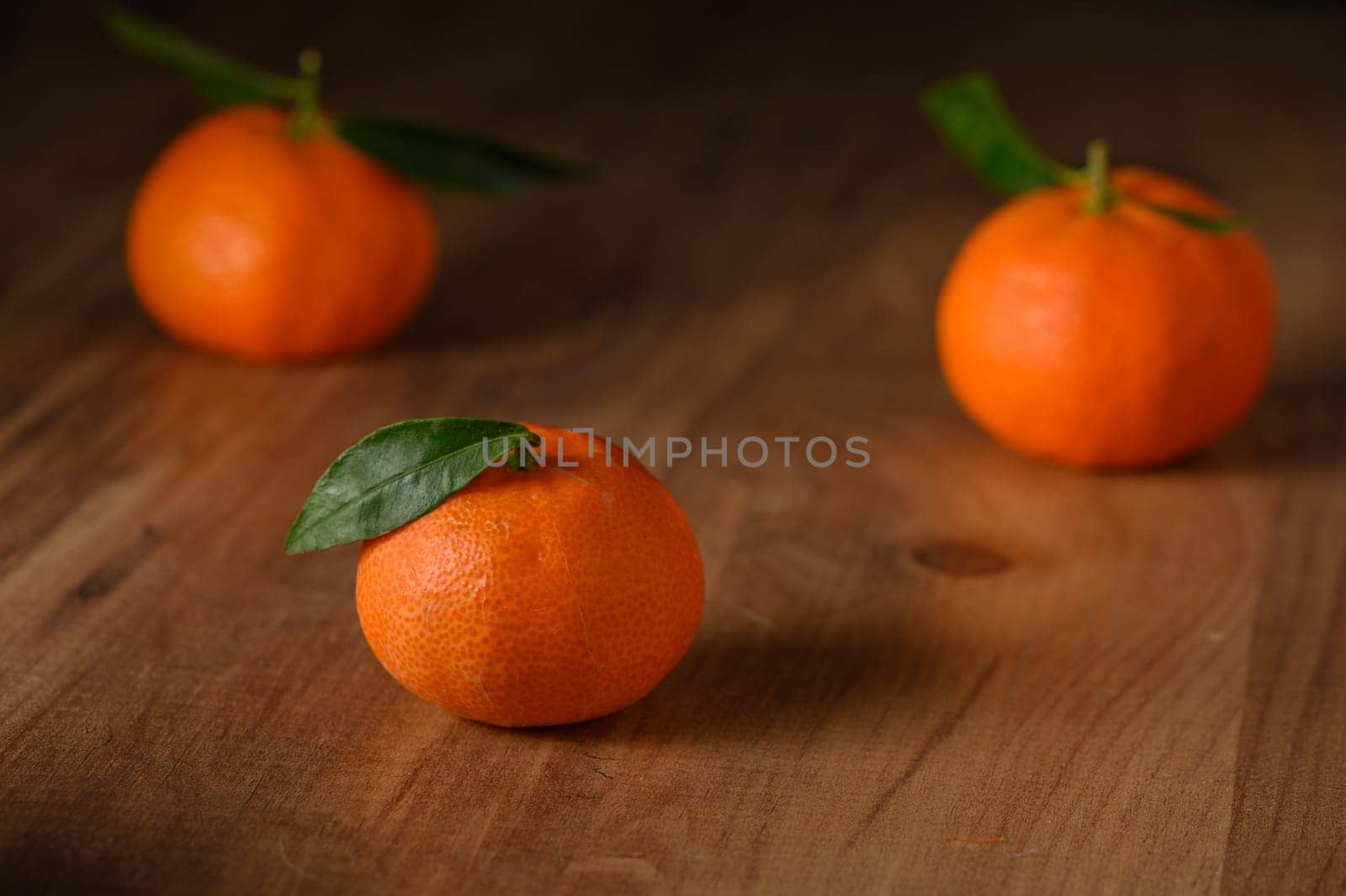 fresh juicy three tangerines on a wooden table 2