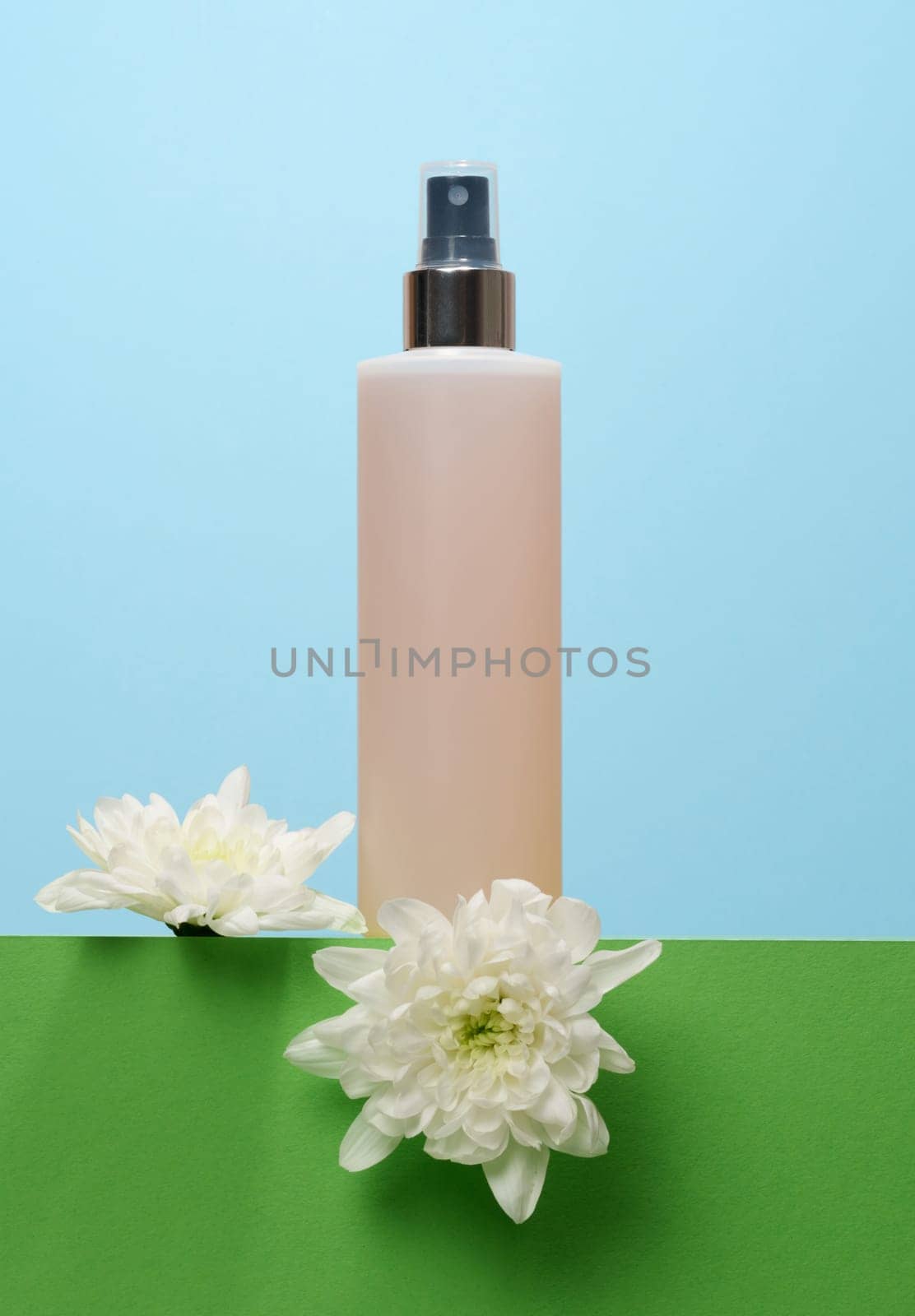 Plastic bottle with sprayer and transparent cap on blue background by ndanko