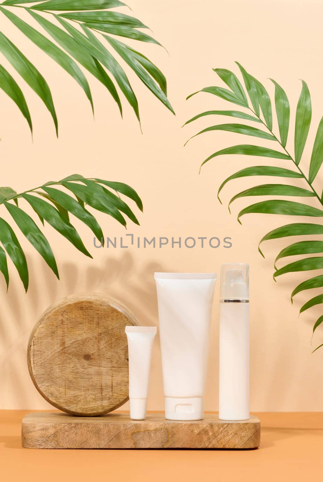 White plastic tubes a beige background, containers for cosmetic creams and gels, advertising and brand promotion