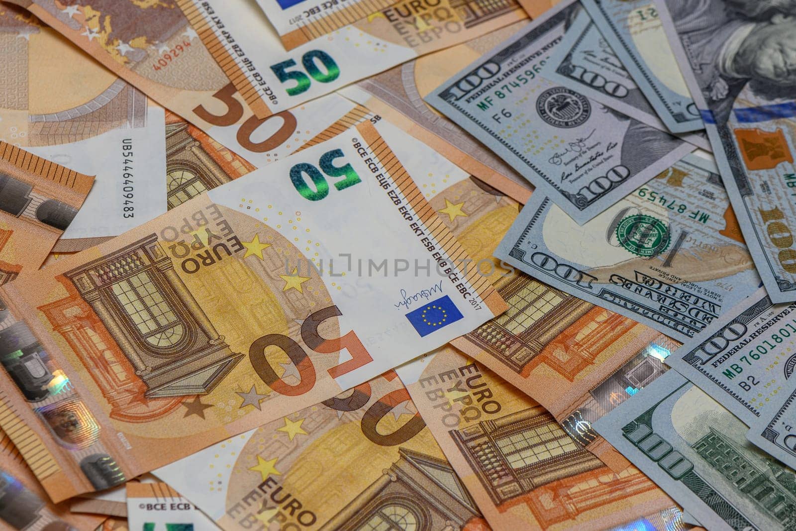 50 euro and 100 dollar bills scattered on the table as a background 9 by Mixa74