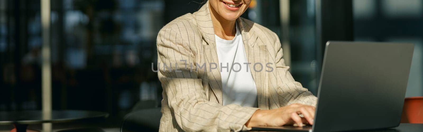 Stylish business woman sitting in modern coworking and working on laptop. High quality photo