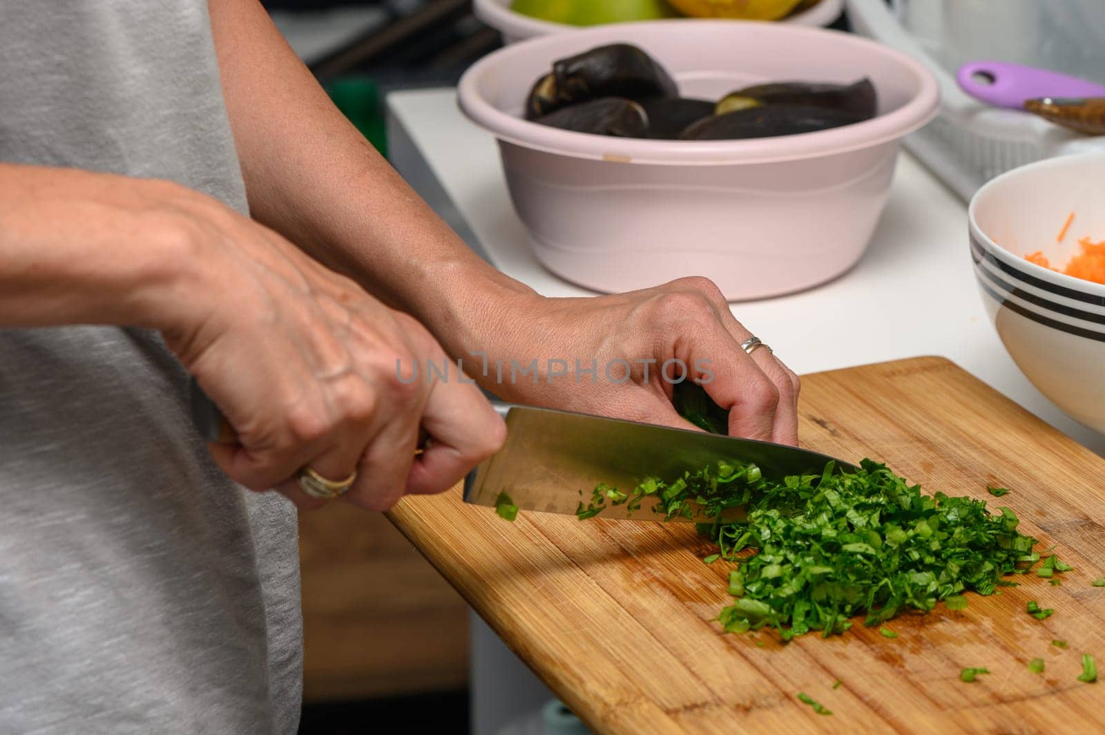 woman cutting parsley on a cutting board in the kitchen 1 by Mixa74