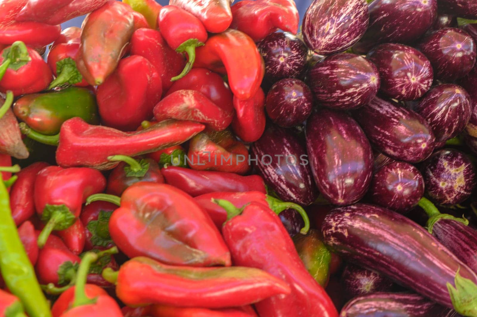 fresh striped purple eggplants and red peppers at the local market