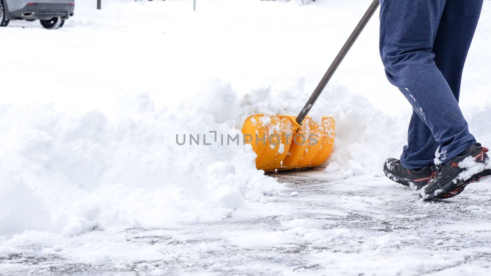 Man shoveling snow off of his driveway after a winter storm in Canada. Man with snow shovel cleans sidewalks in winter. Winter time