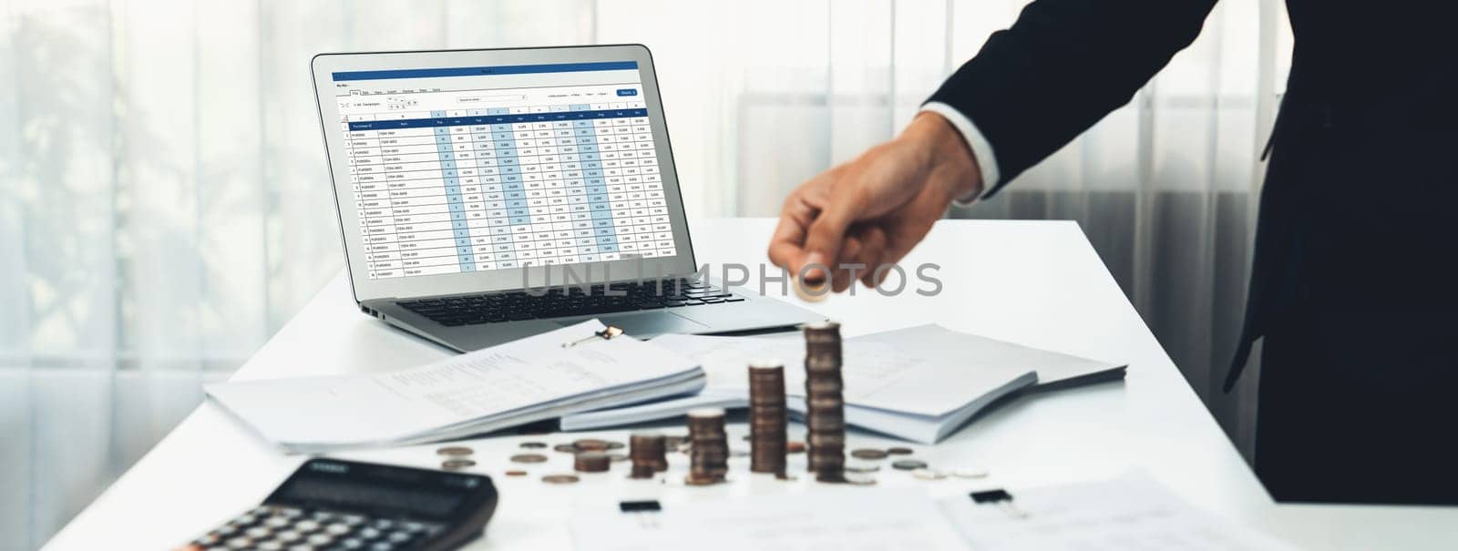 Corporate accountant use accounting software on laptop to calculate and maximize tax refunds and improve financial performance with business investment concept of growth stack coin in panorama. Shrewd