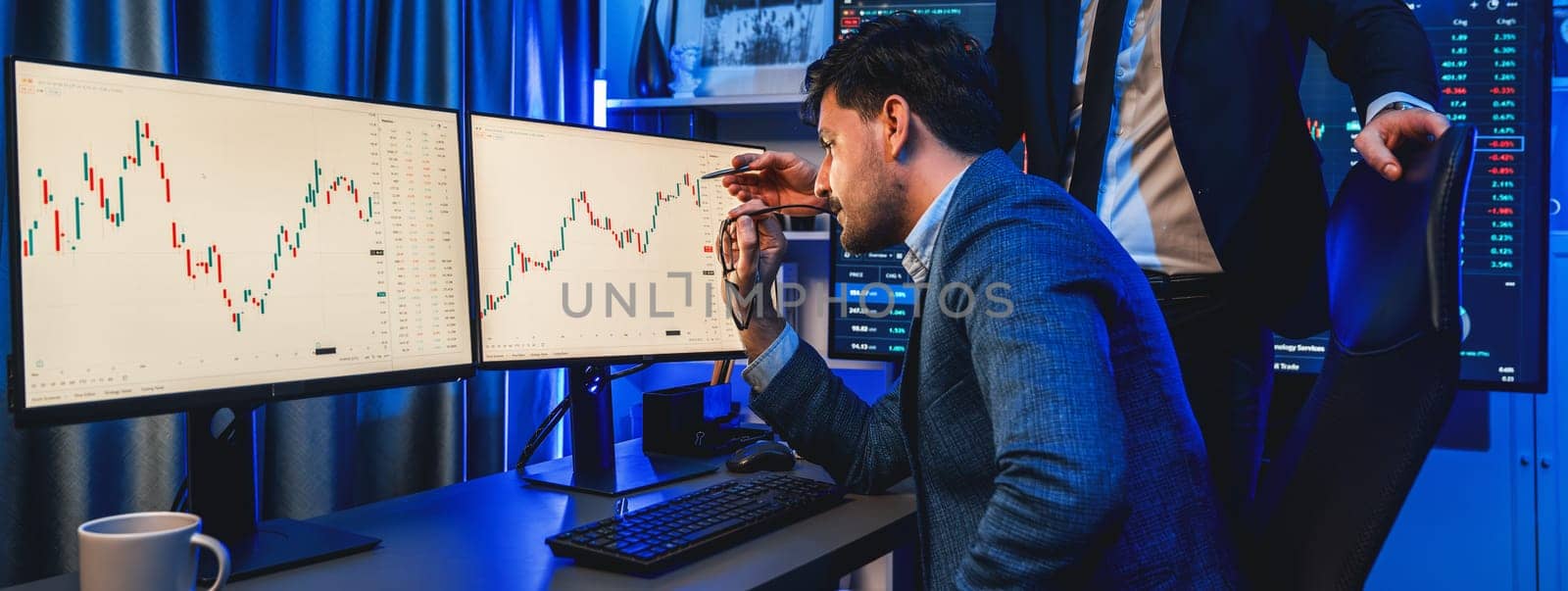 Stock exchange traders looking on high profit chart investment in panorama view, analyzing on monitor at night. Concept of discussing financial technology growth in neon light at workplace. Sellable.