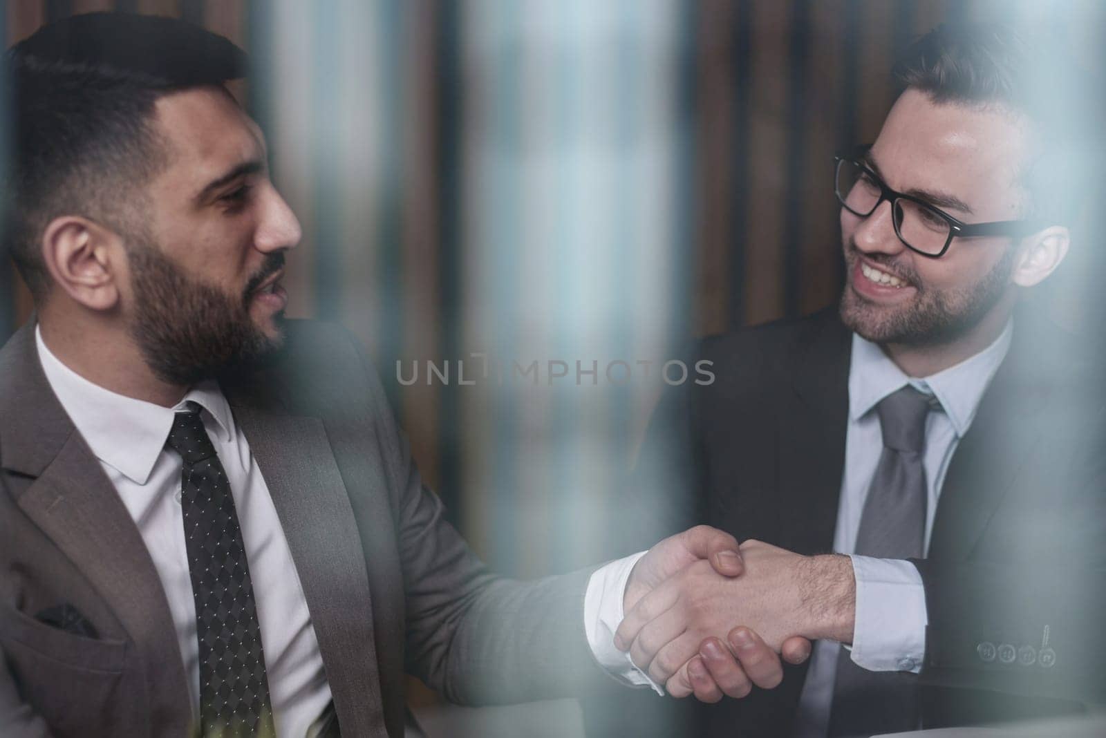 Two happy people make a good business deal and exchange confident handshakes. by Prosto
