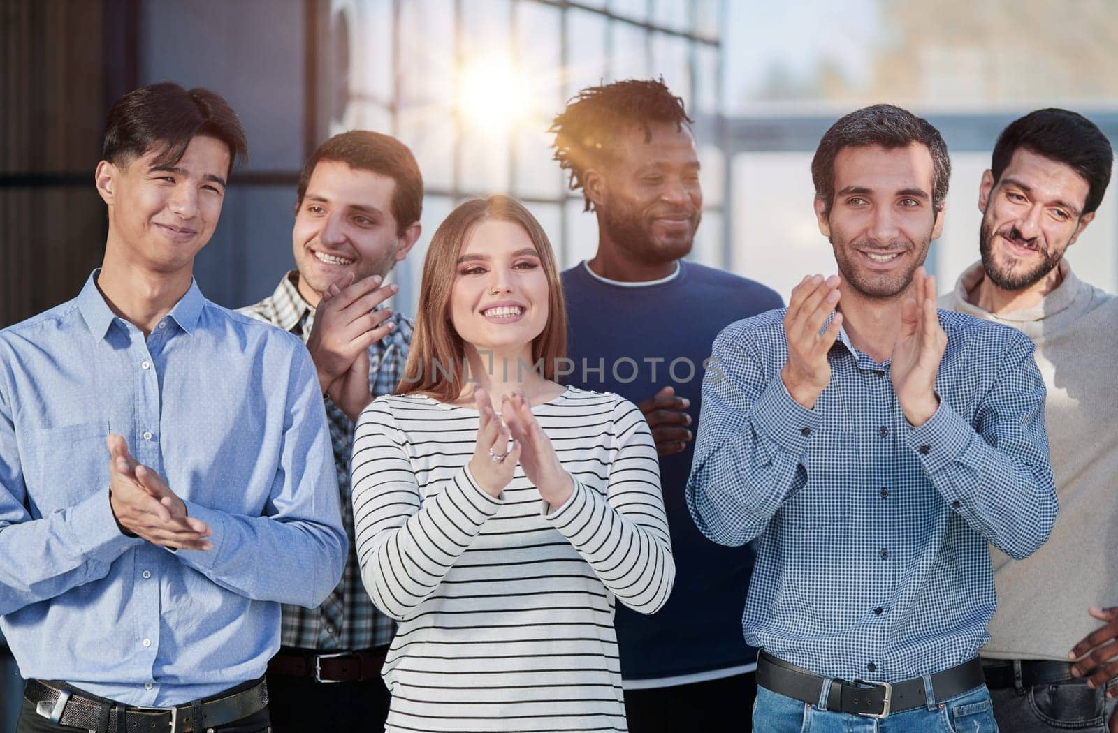 Human resources. Group portrait of smiling employees of a friendly team of different racial genders standing together in an office. by Prosto