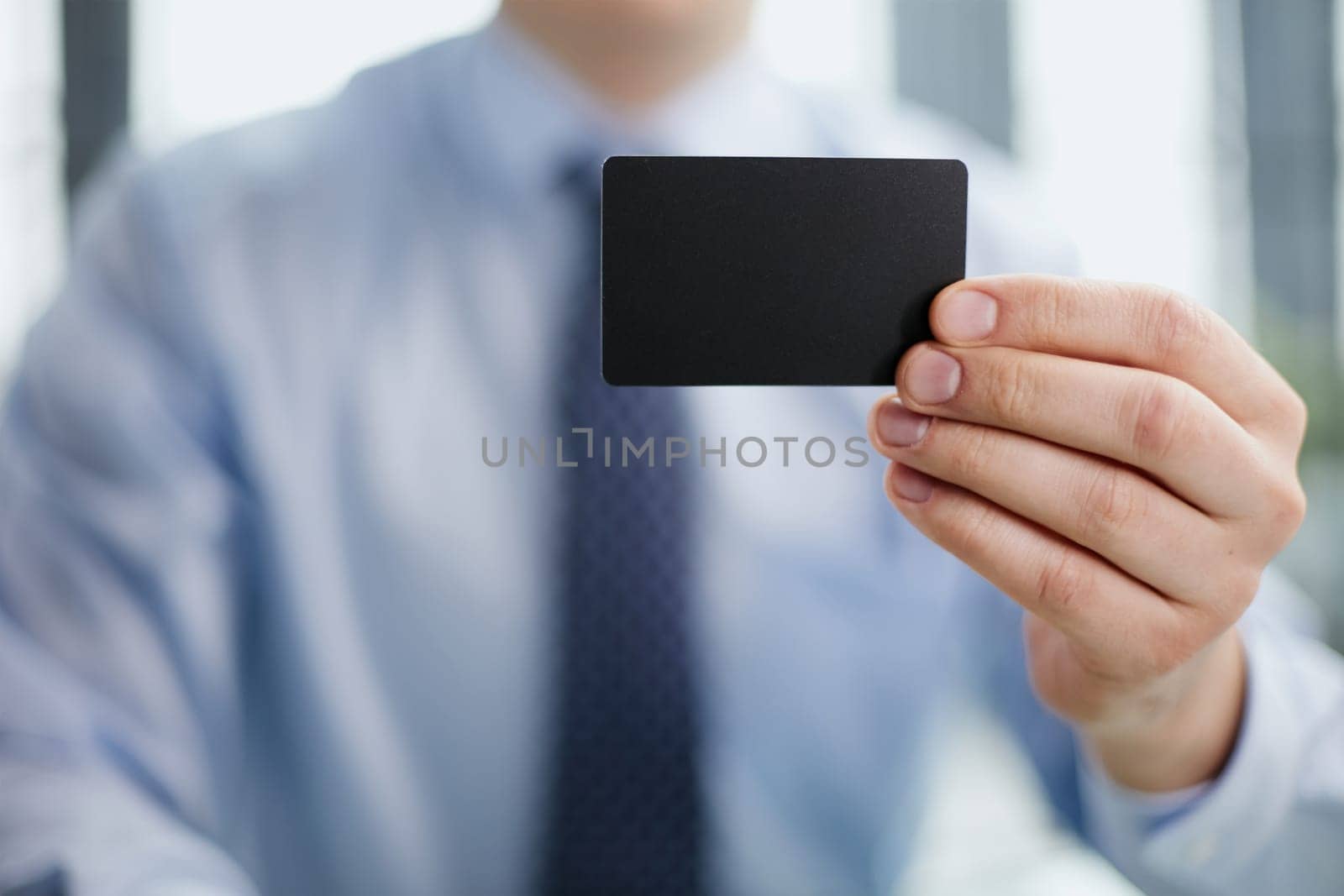 A man holds a black business card. A paper in the hands of a man. Prepared for your text. by Prosto
