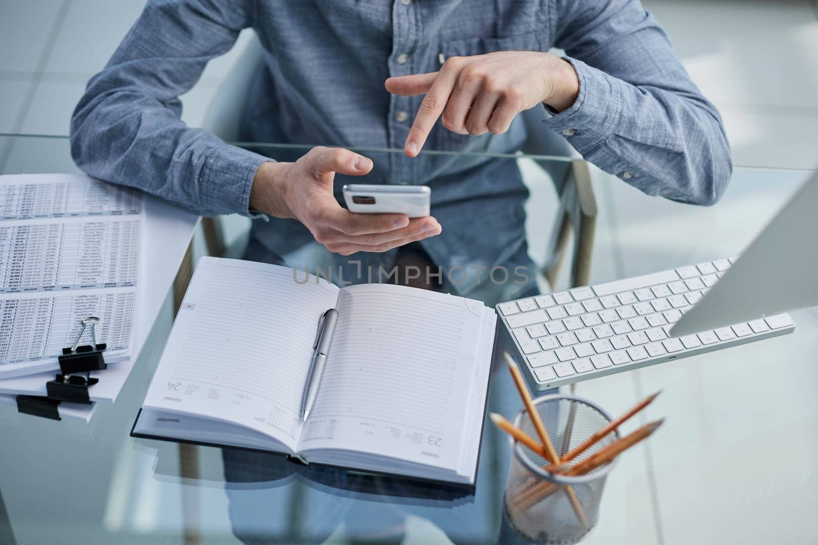 businessman professional executive holding mobile working at desk with smartphone.