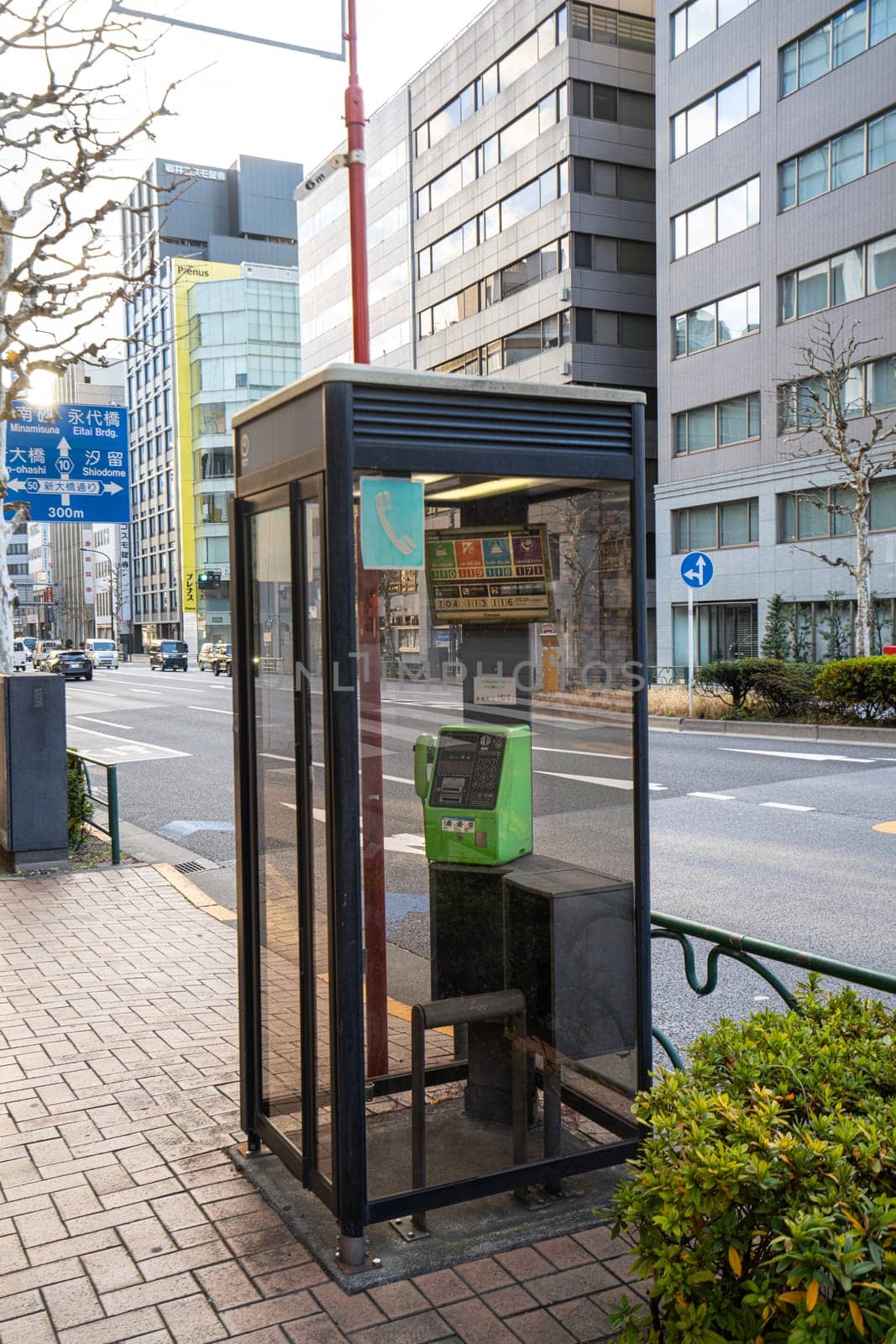 Tokyo, Japan, January 2024. a public telephone booth on the pavement of a street in the city center
