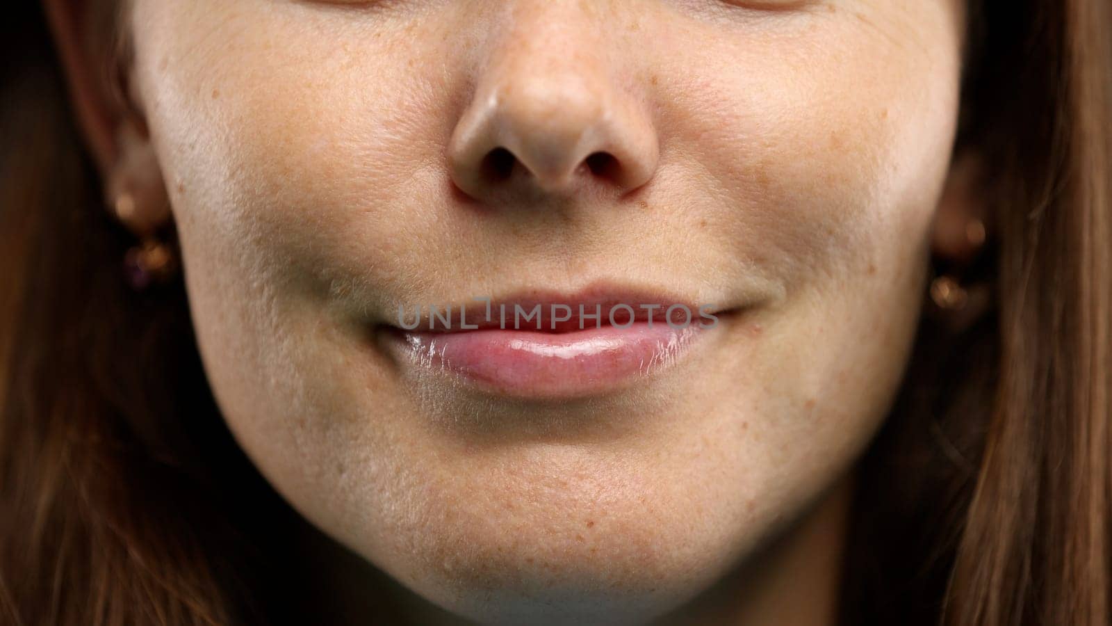 Woman's face, close-up, on a green background.