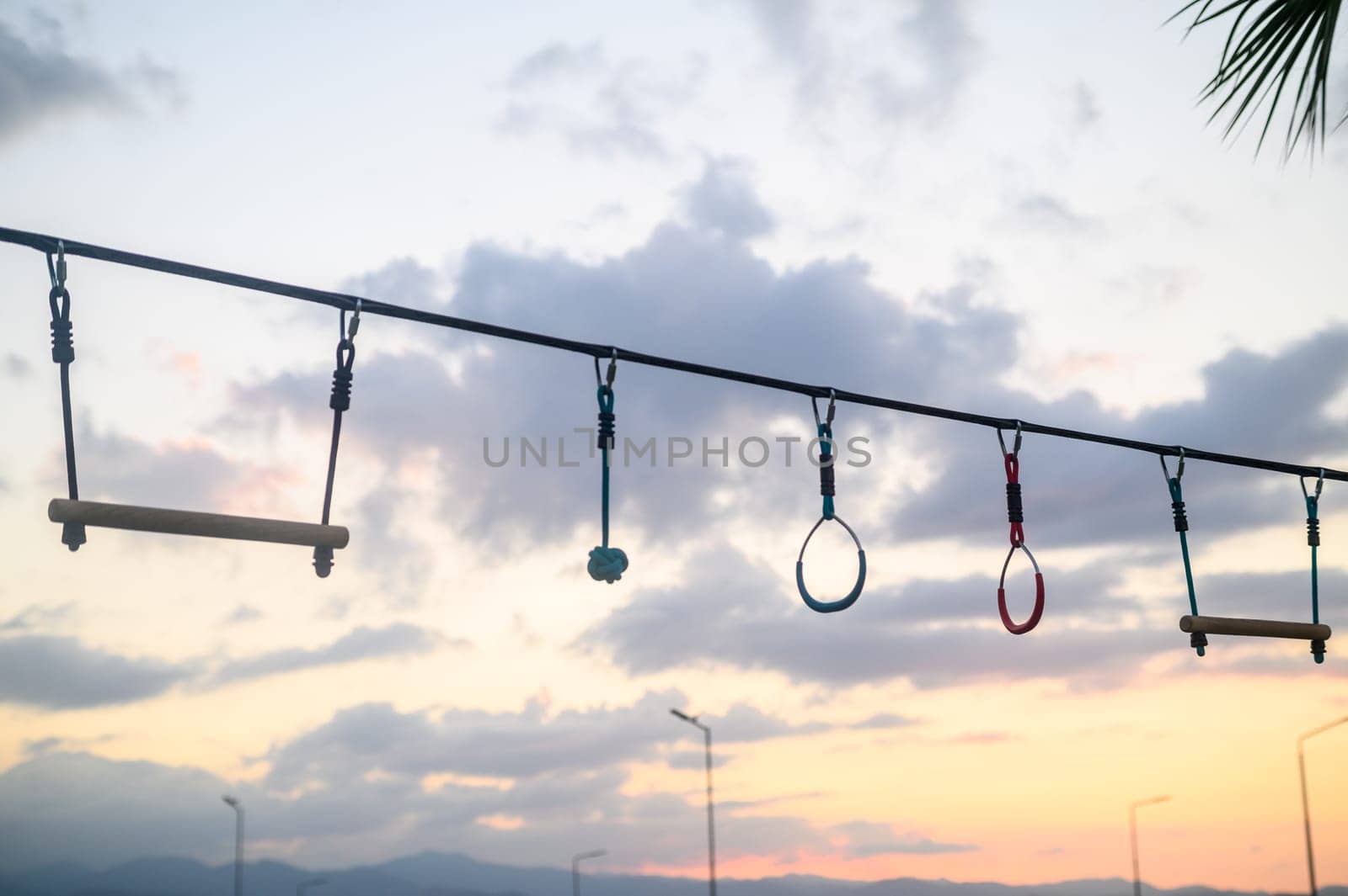 children's entertainment - rings, swings, stairs against the backdrop of sunset