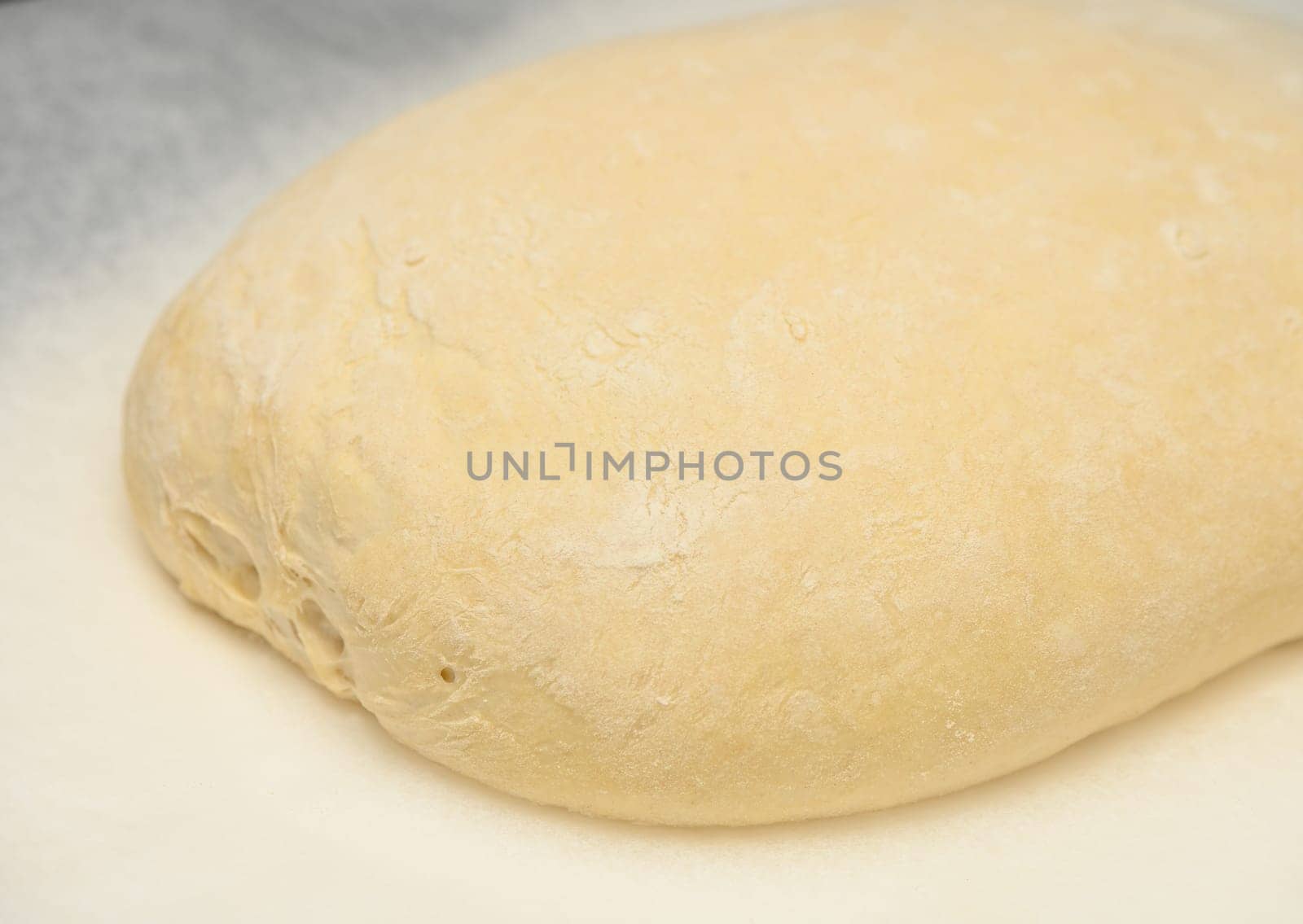 dough for homemade bread lies on the kitchen table before going into the oven 3 by Mixa74