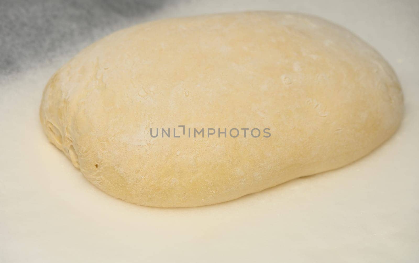 dough for homemade bread lies on the kitchen table before going into the oven by Mixa74