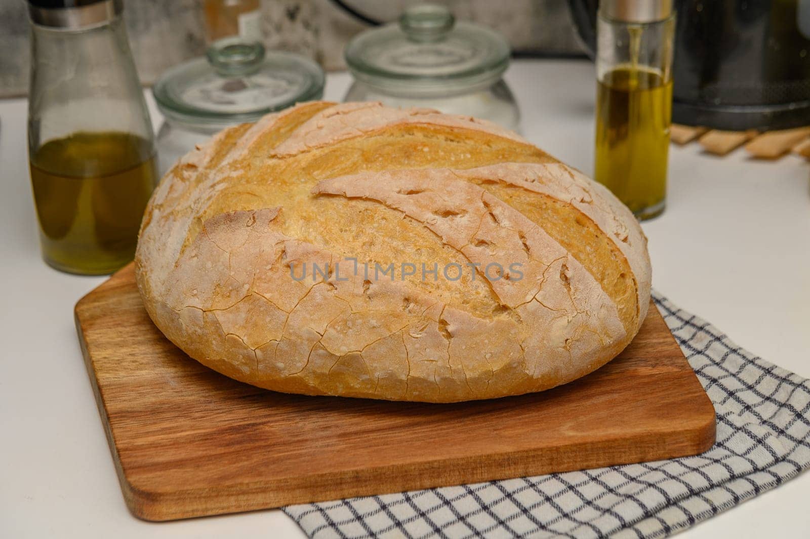 freshly baked homemade bread on the kitchen table on a light background 1 by Mixa74