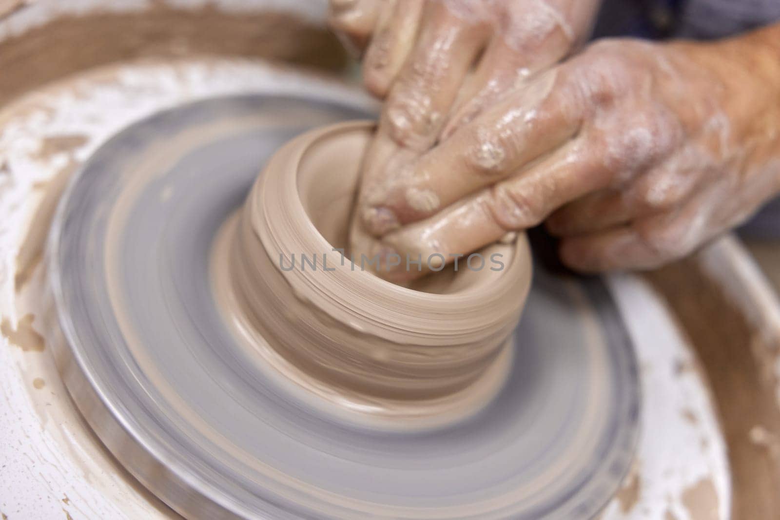 male hands making ceramic cup on pottery wheel, Close-up