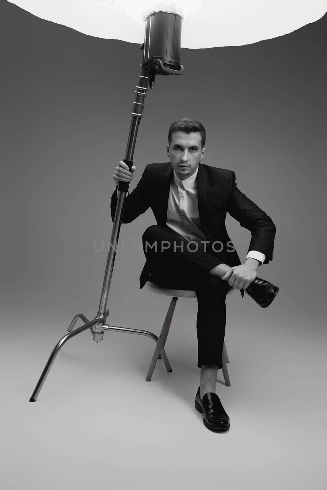elegant model man in black suit in photostudio. by erstudio