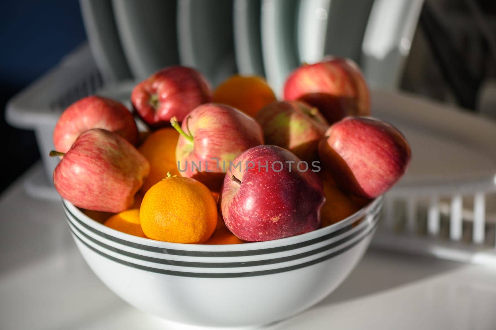 red apples on a white plate in the kitchen