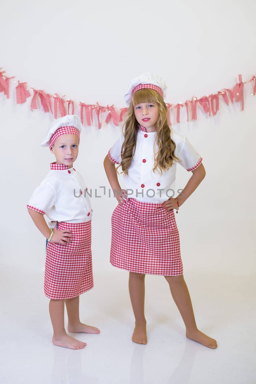 children with red and white chef's hat and apron. children cooking, healthy eating by jcdiazhidalgo