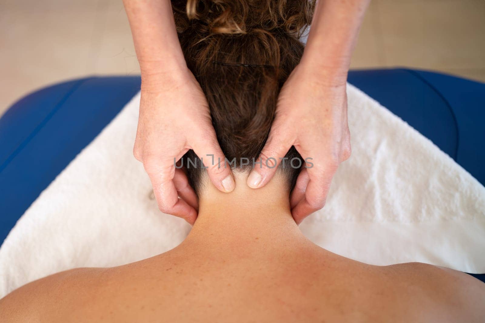 Crop masseuse massaging trigger points on neck of woman by javiindy