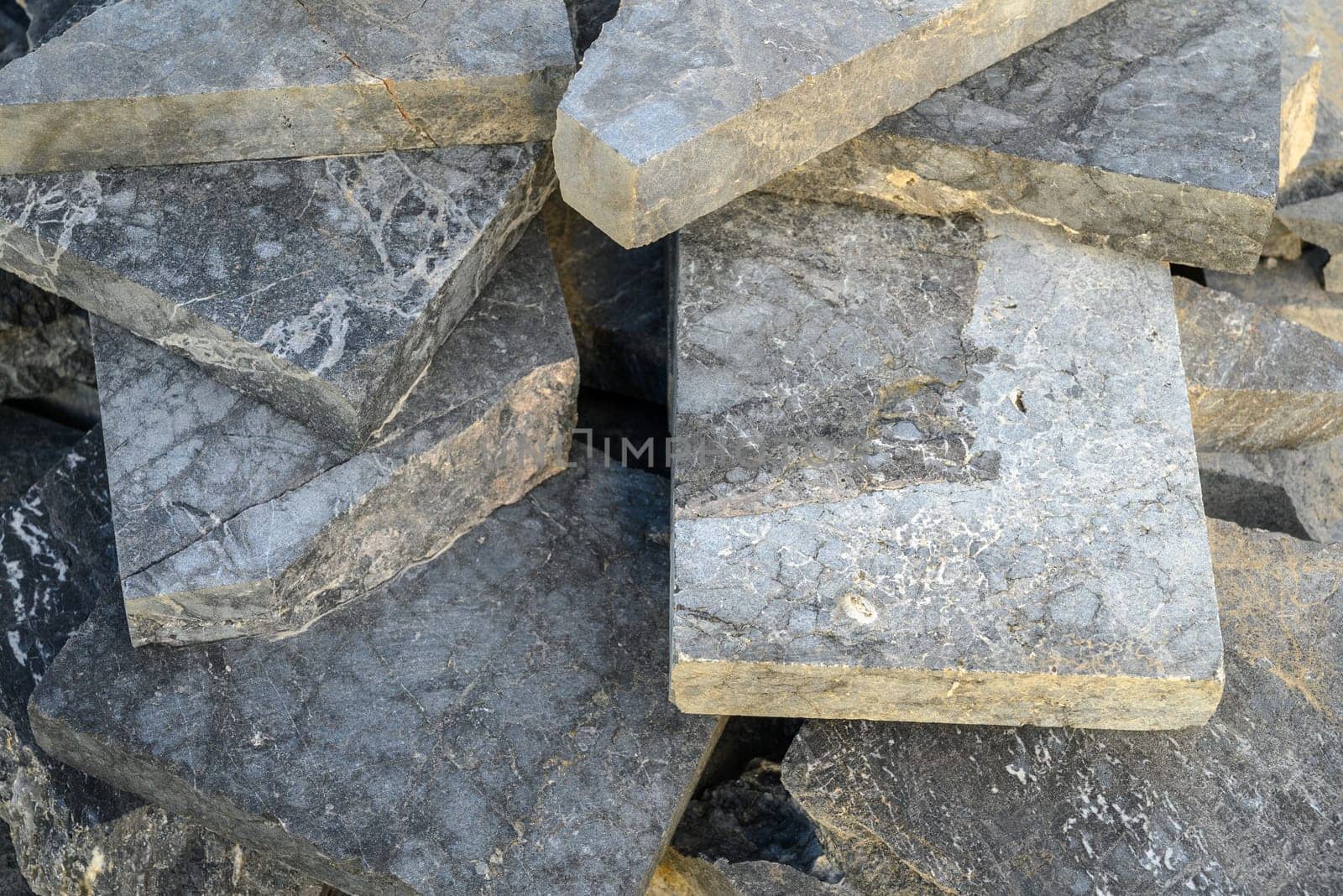 pieces of stone for paving lie in a heap as a background 3