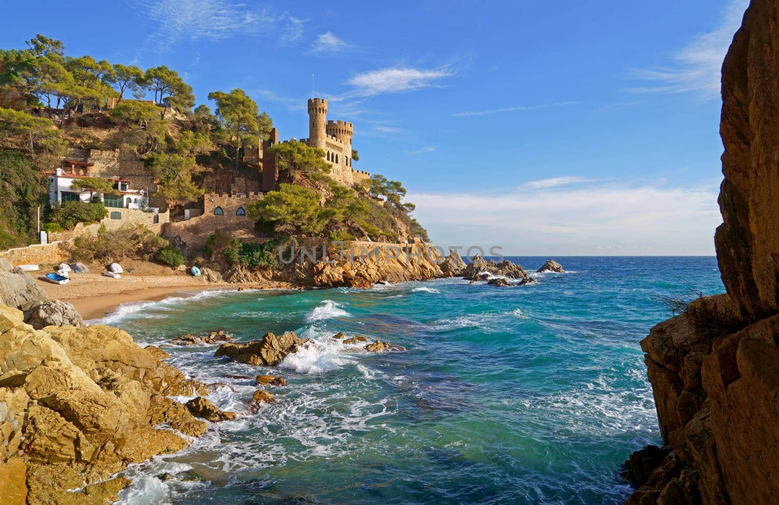 Spain. Coast of the Costa Brava. Catalonia. Lloret de Mar. Mediterranean Sea. Beautiful rocks. A sea wave hits the shore.