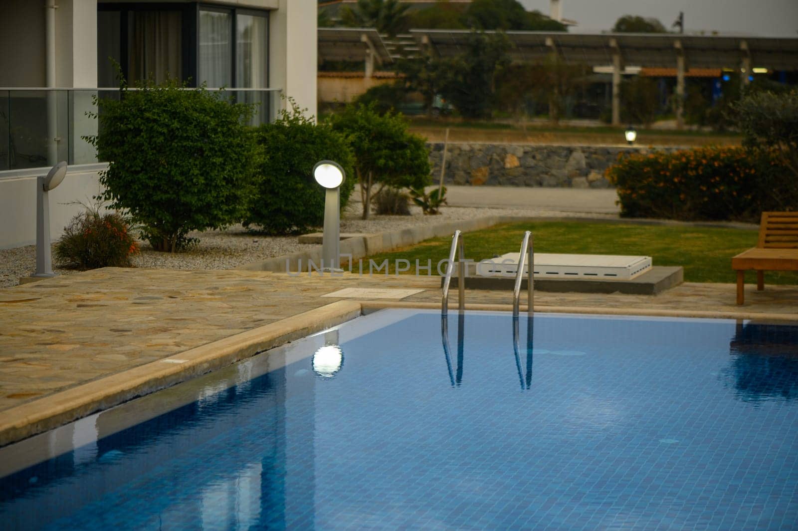 swimming pool near a house in a residential complex at sunset