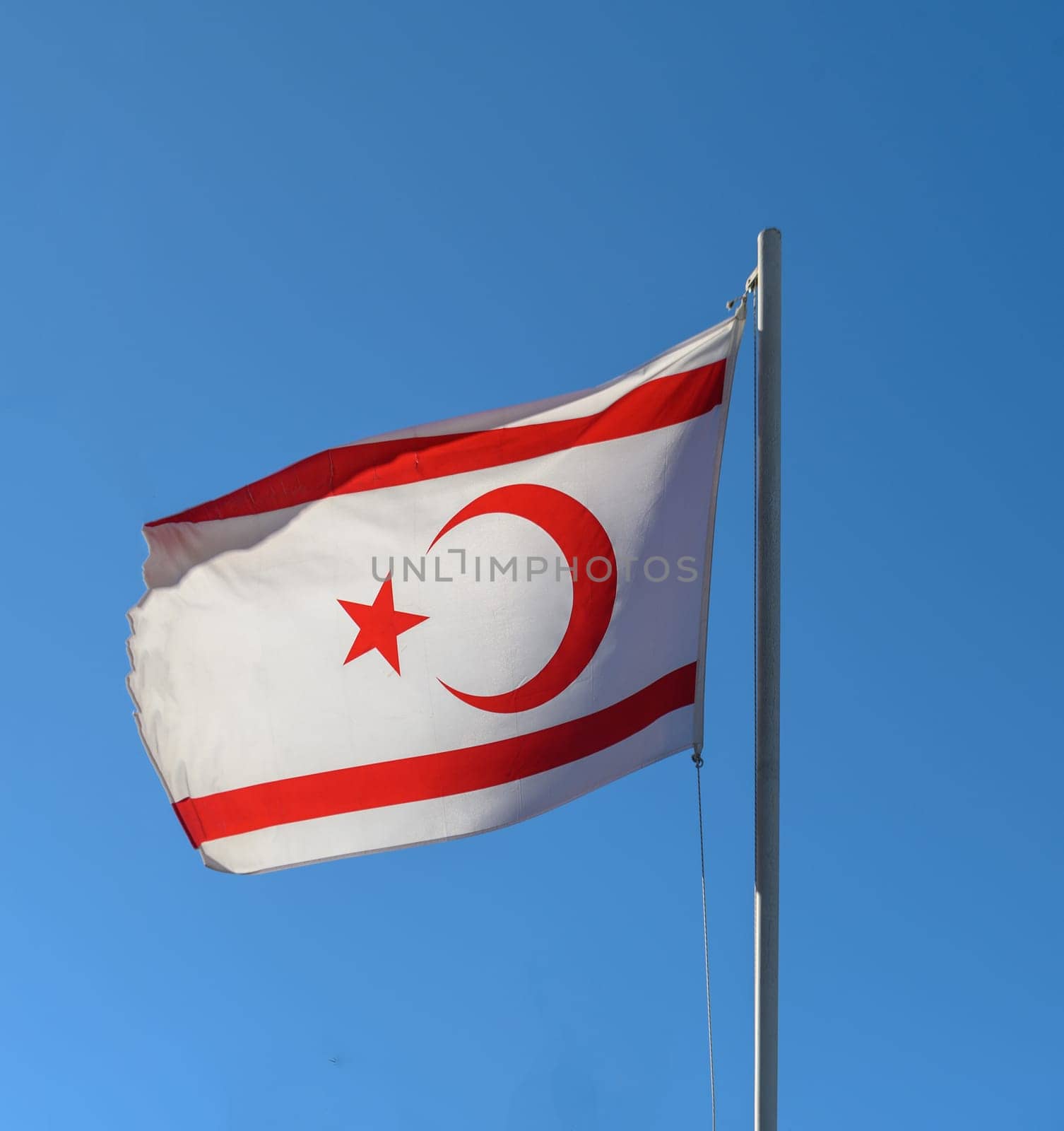 flag of the Turkish Republic of Northern Cyprus against a blue sky