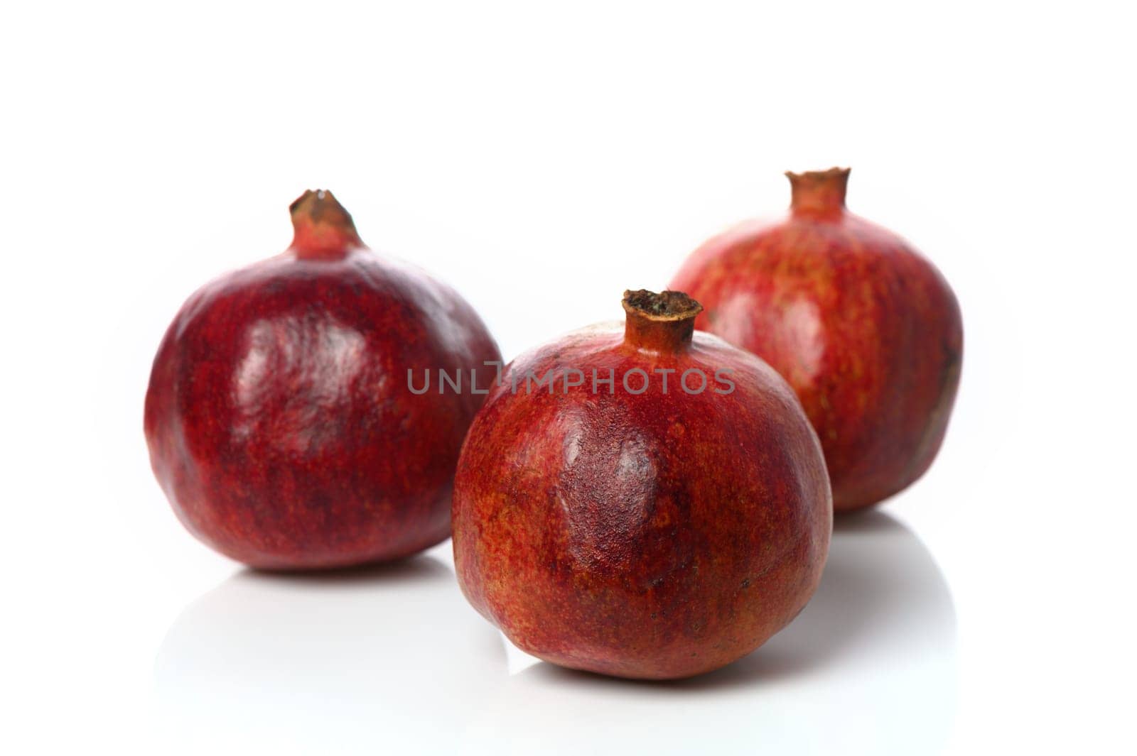 three pomegranates on a white background