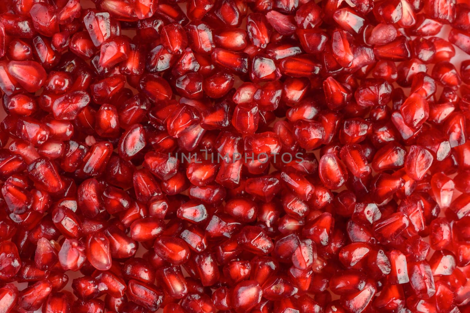 juicy pomegranate seeds on white background