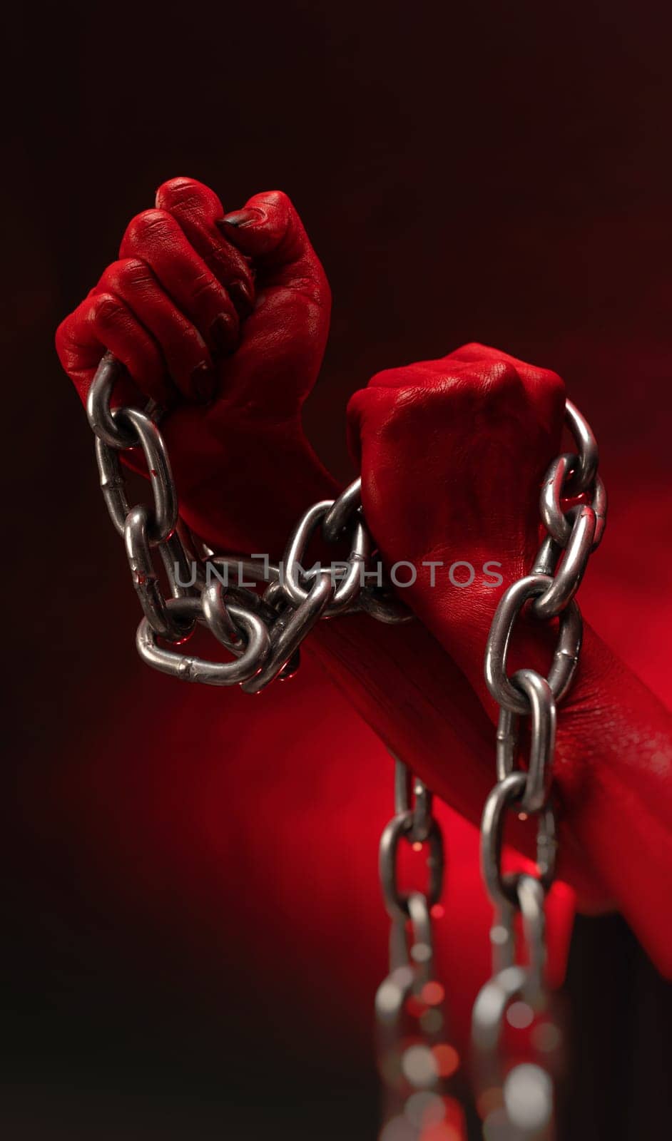 bloodied hands clenched into fists in the shackles of a metal chain symbolize slavery, protest and the struggle for freedom by Rotozey