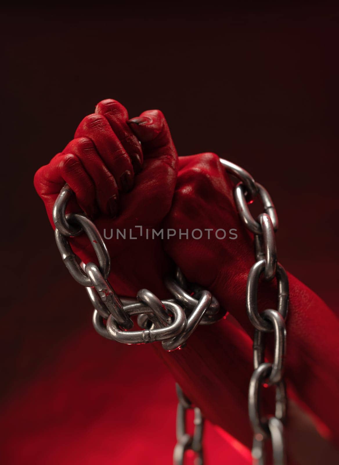 bloodied hands clenched into fists in the shackles of a metal chain symbolize slavery, protest and struggle for freedom