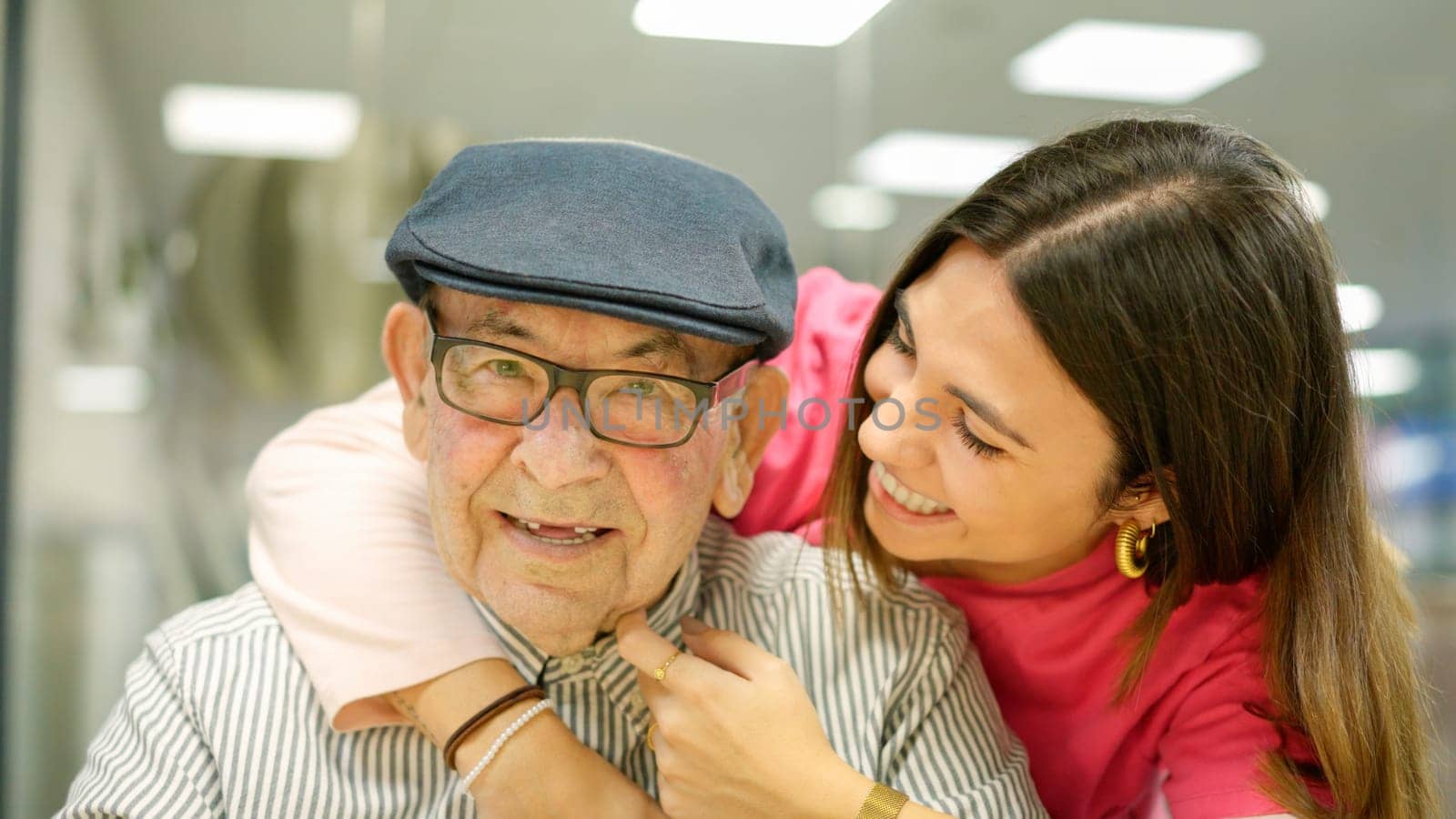 Photo of a kind nurse embracing a senior man in a nursing home