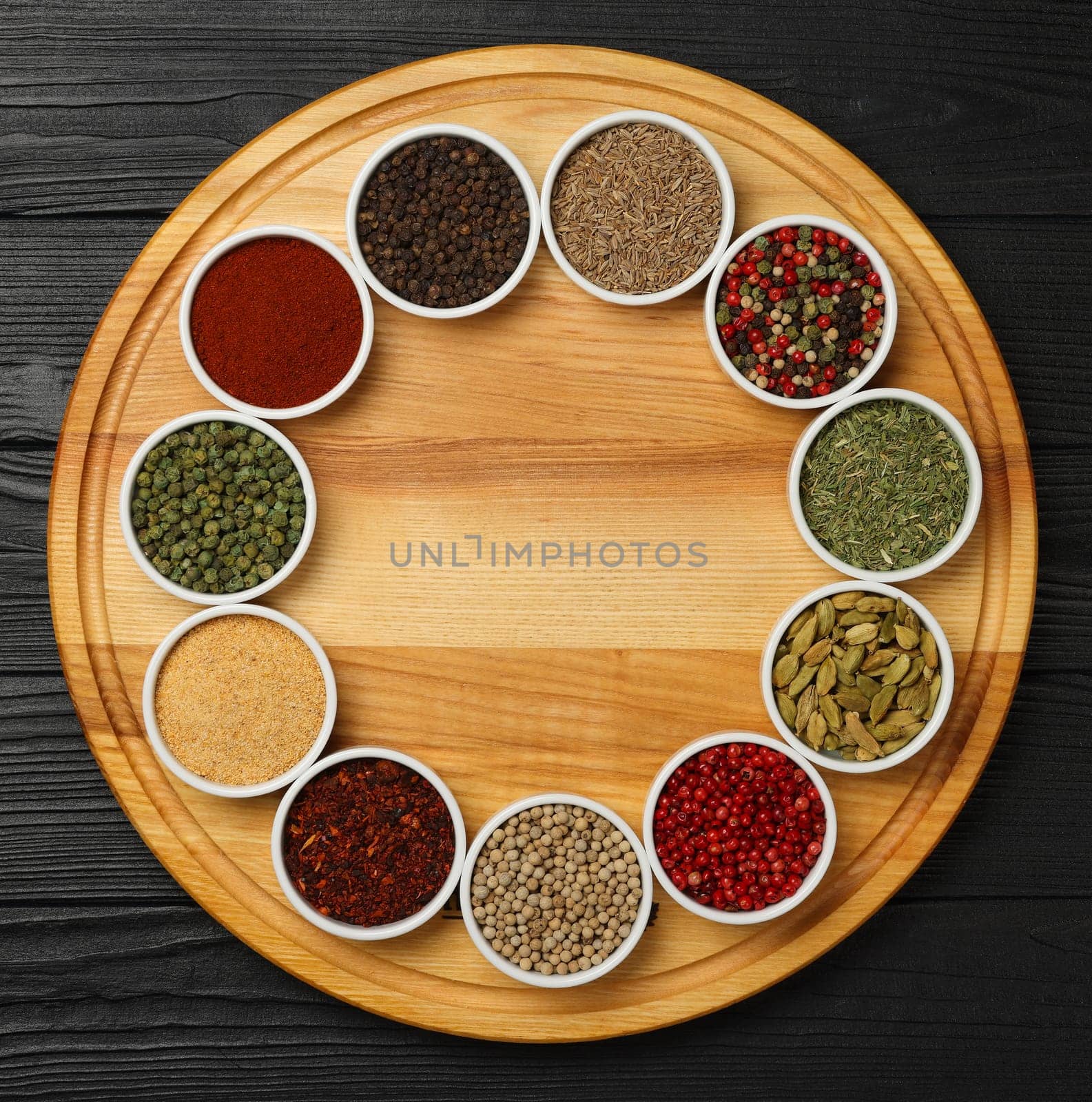 Circle of assorted spices in bowls by BreakingTheWalls