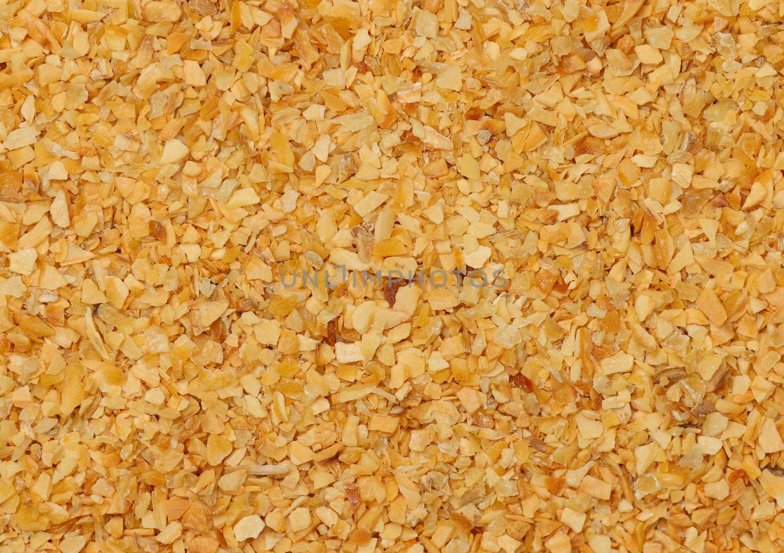 Background of dried garlic flakes spice, natural condiment pattern texture, elevated top view, directly above