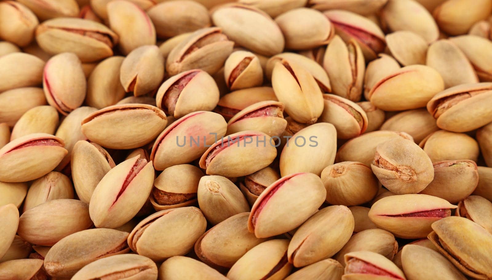 Background texture of fresh roasted pistachio nuts, elevated, high angle top view