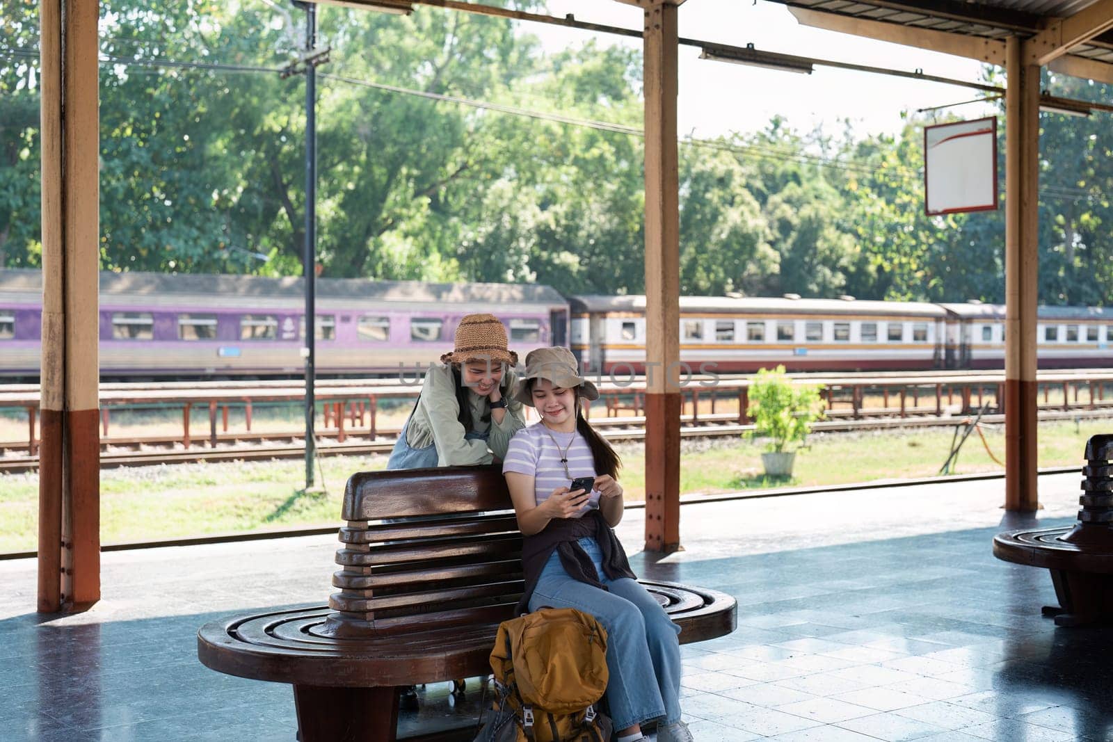 Asian woman friends at railway station have happy moment. Tourism and travel.