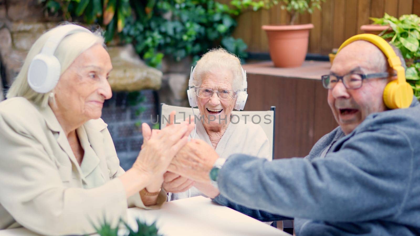 Photo of three senior people celebrating and greeting together in a geriatric