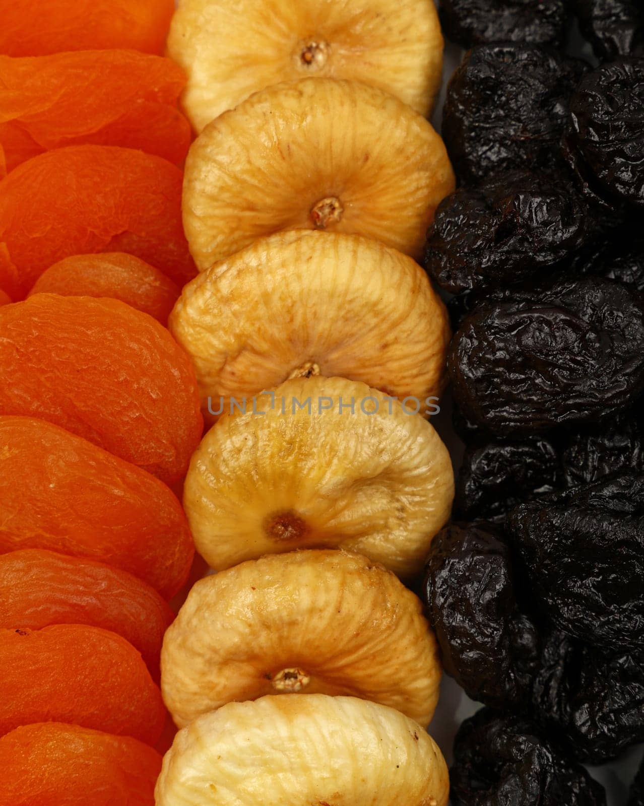 Close up background pattern of assorted sundried fruits, plums, apricots, figs, high angle view