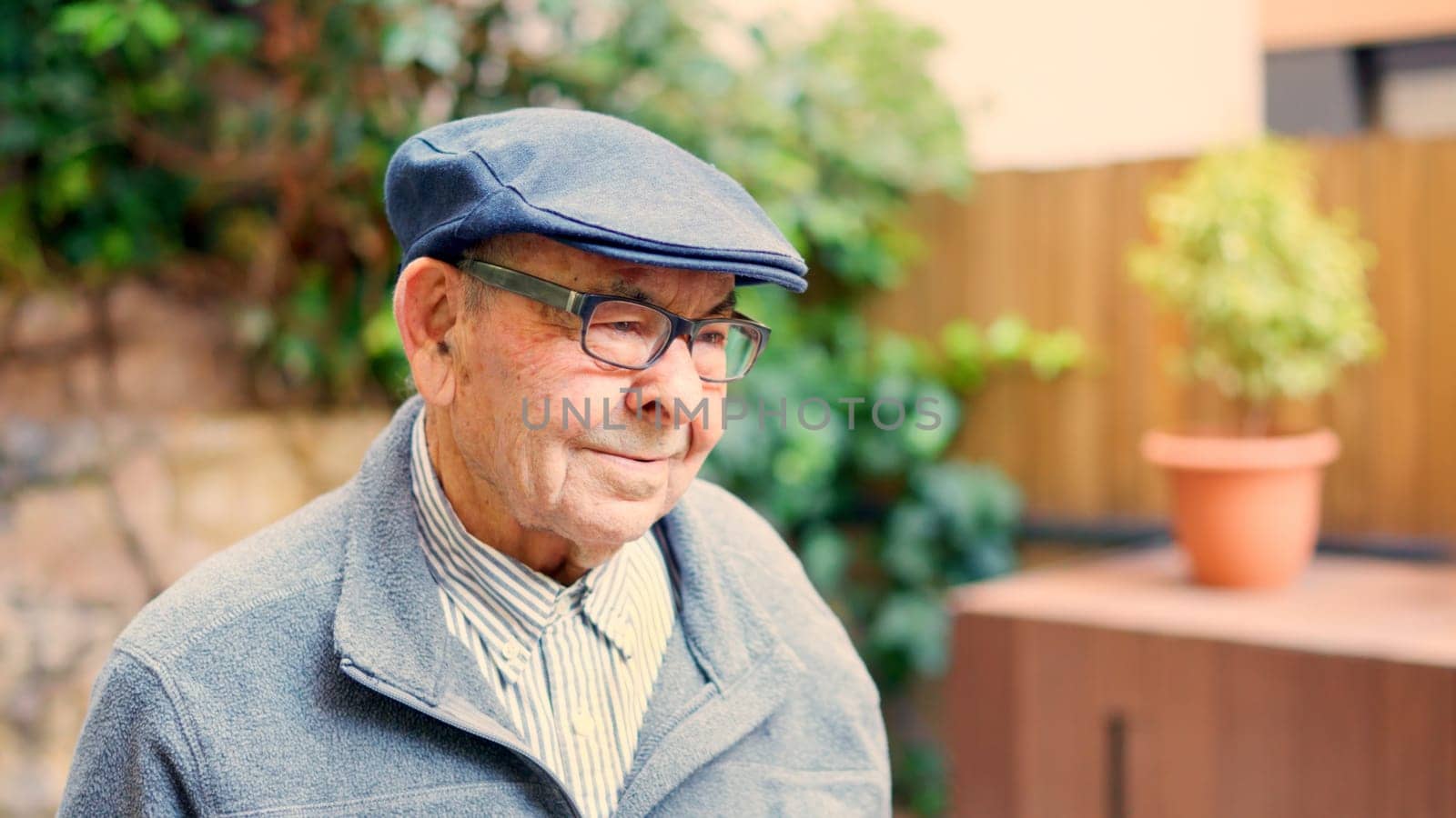 Distracted grandfather looking away in the garden of a nursing home