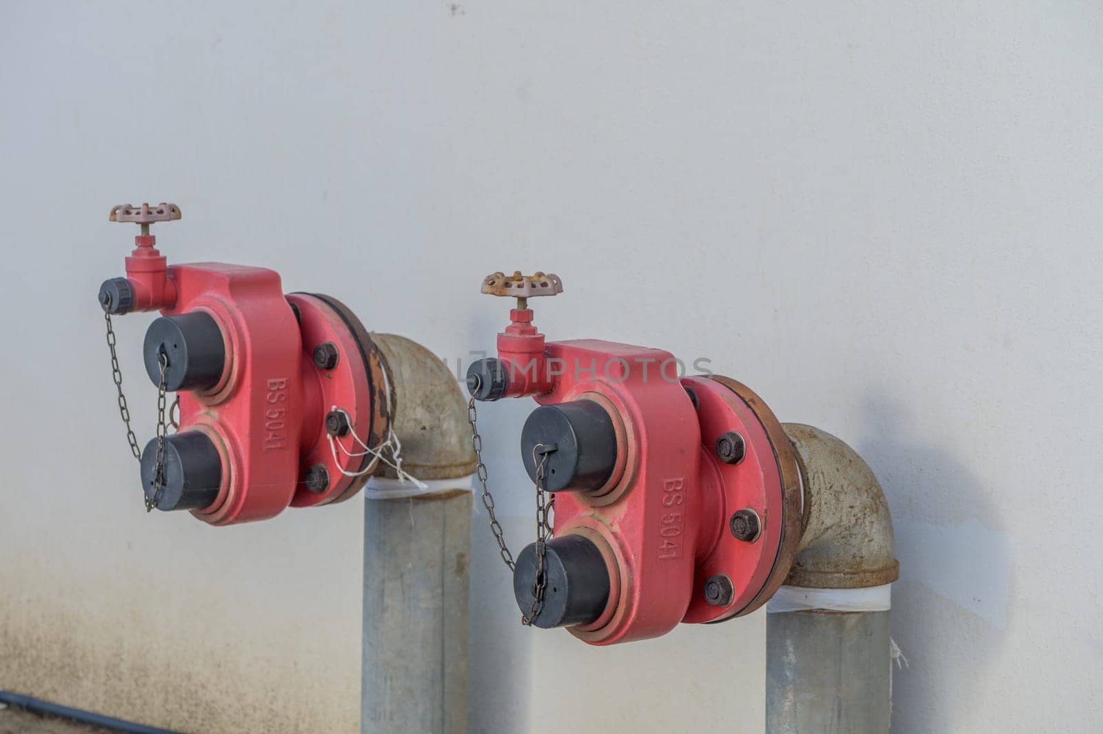 fire hydrants on a white house wall