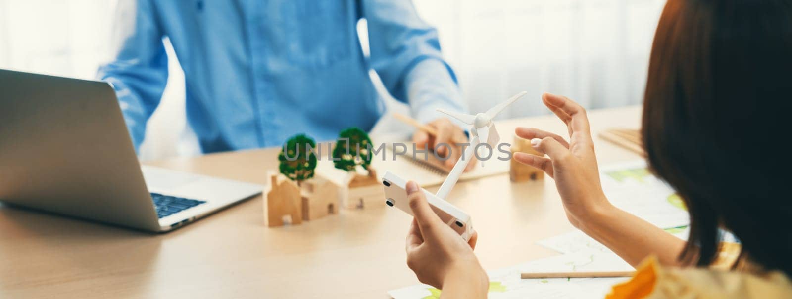 Businesswoman interested in investing in renewable energy at meeting table with environmental document scatter around. Business team discussion about green business project. Closeup. Delineation.