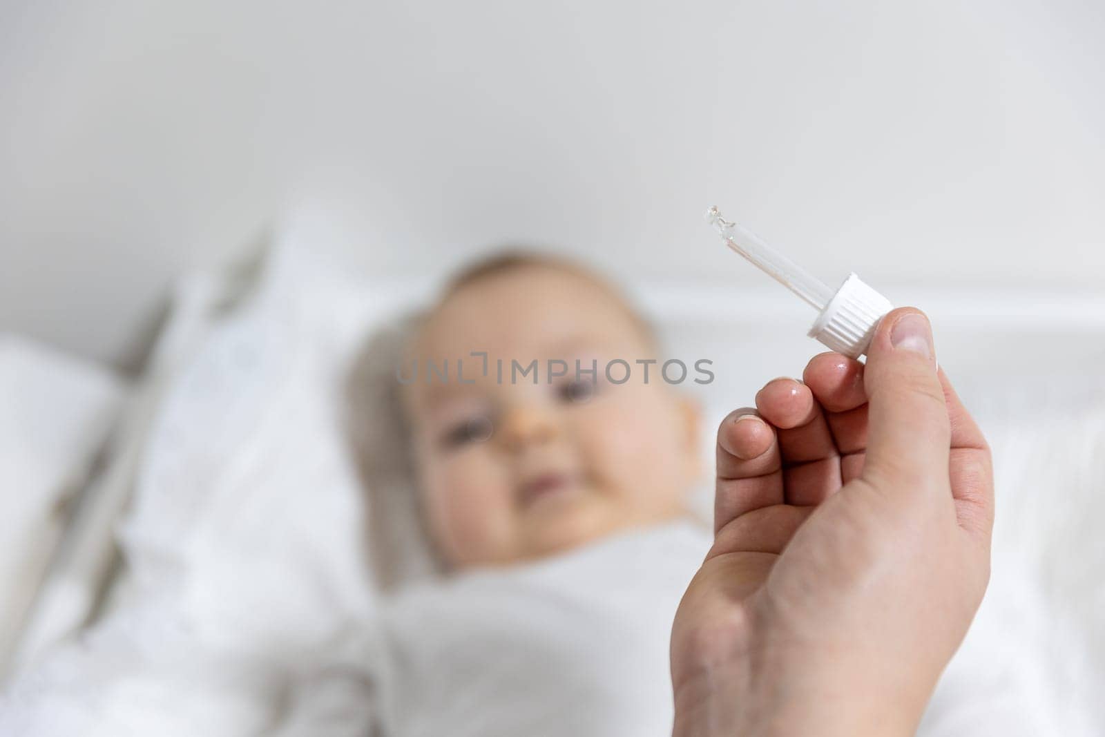 Mom giving vitamin D3 to a newborn baby for care of the proper functioning of muscles and bone formation, healthcare concept