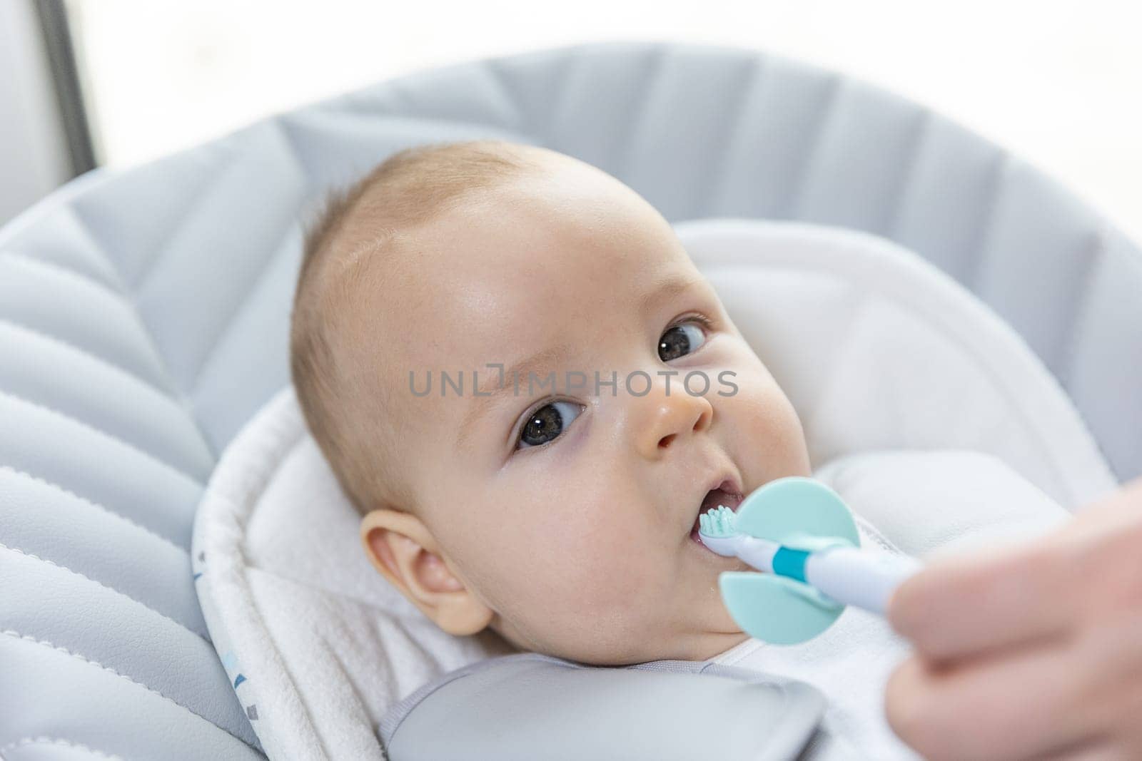 Newborn baby suffering of his tooth growth, mom using a teether to ease the pain, healthcare concept by Kadula