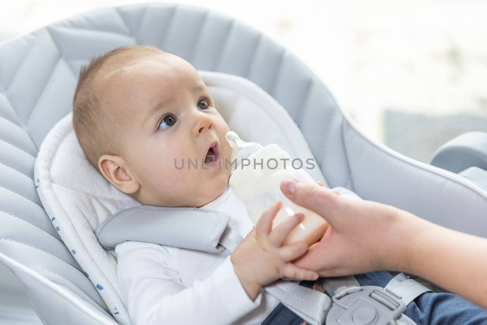 Newborn baby drinking water from a bottle, healthcare concept by Kadula