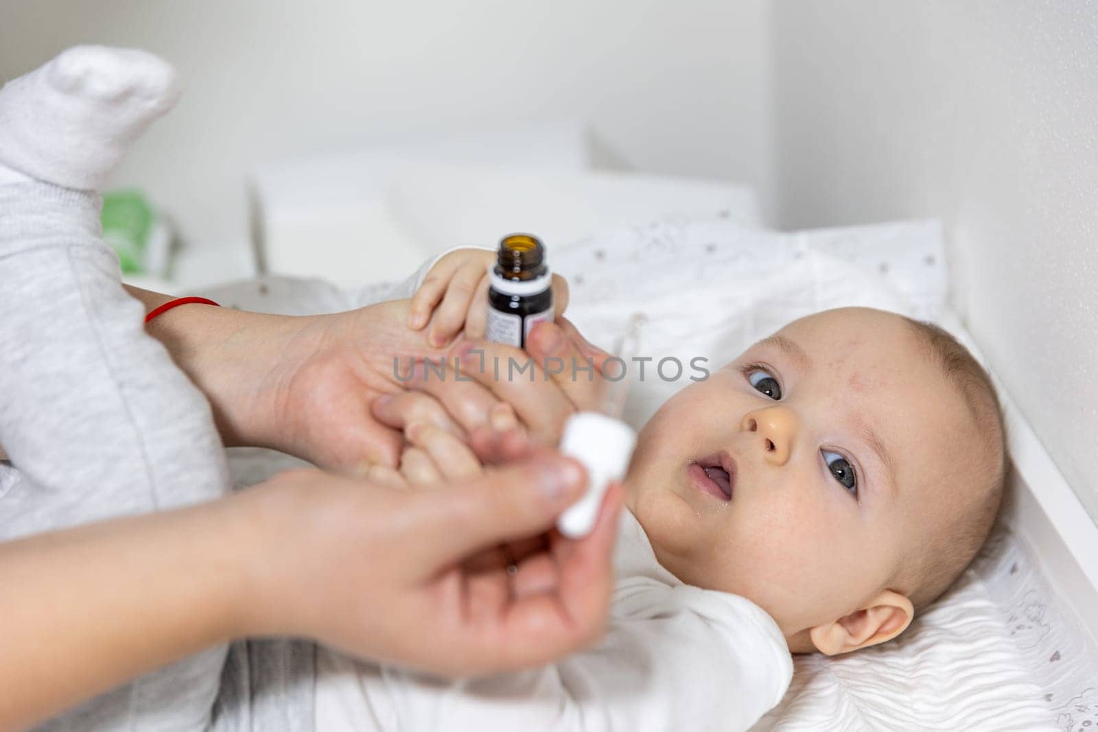 Mom giving vitamin D3 to a newborn baby for care of the proper functioning of muscles and bone formation, healthcare concept