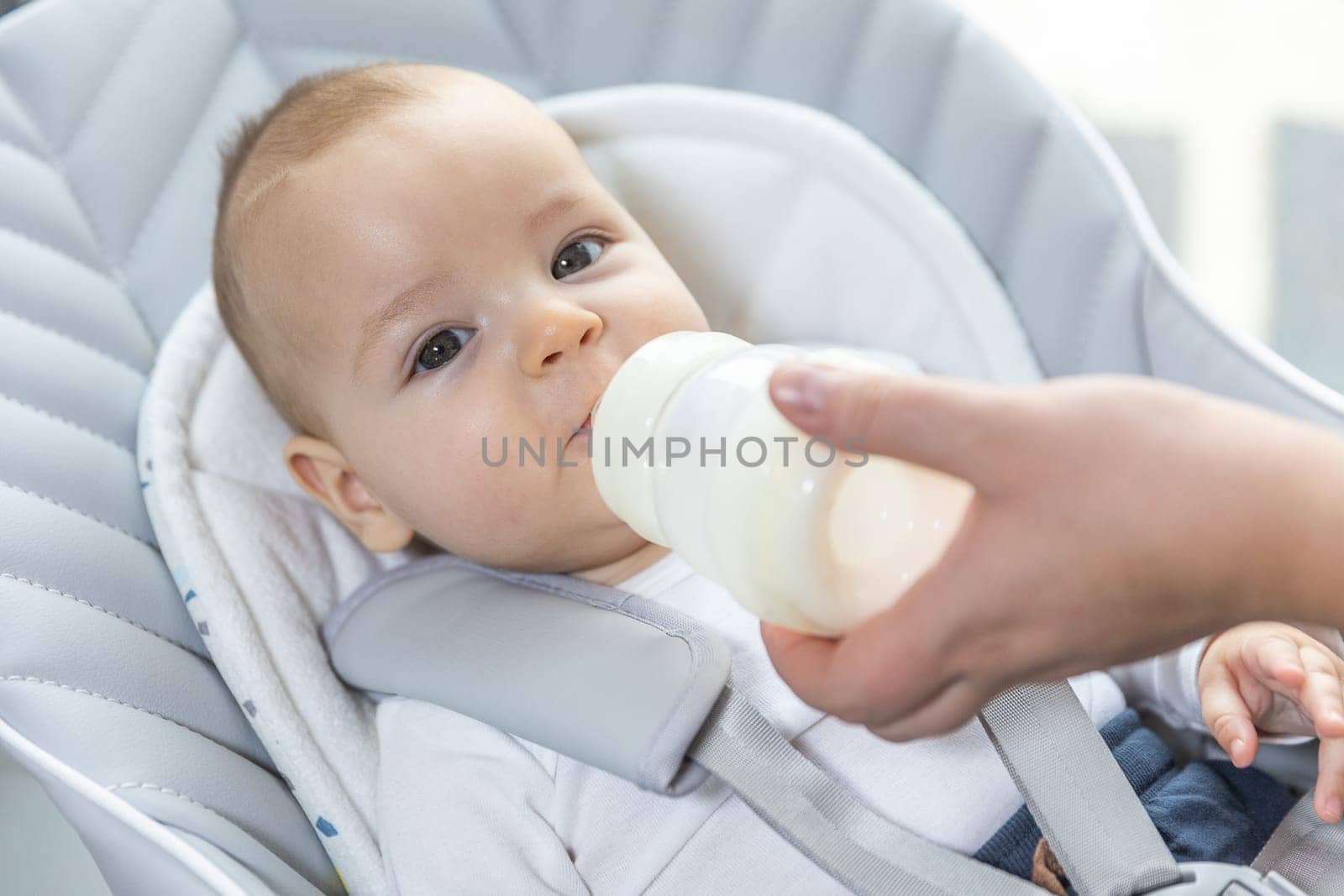 Newborn baby drinking water from bottle, healthcare concept