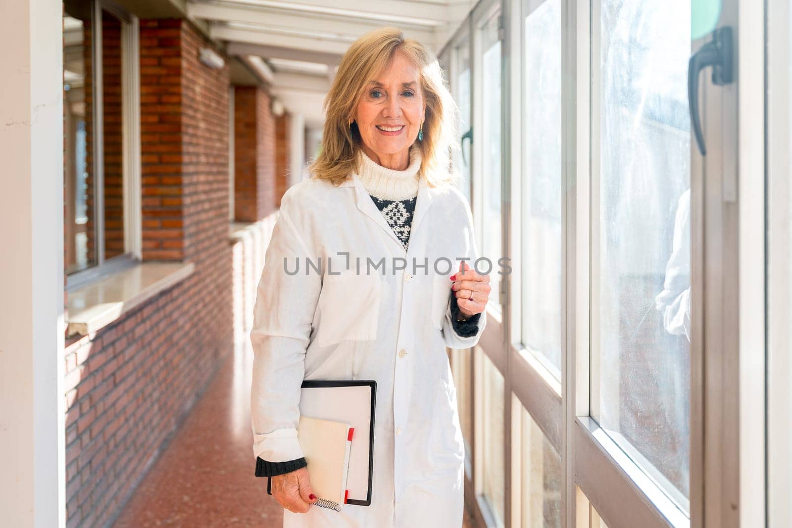 Portrait with copy space of a happy mature doctor standing in the corridor of an hospital